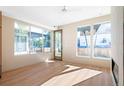 Bright living room boasts large windows, a ceiling fan, and natural light; door to outdoor area at 2325 S High St, Denver, CO 80210