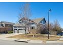 View of a blue two-story home with well-kept landscaping, three car garage, and a bright blue sky at 543 Springvale Rd, Castle Rock, CO 80104