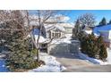 Two-story house with attached garage and driveway, surrounded by trees at 6990 Orchard Ct, Arvada, CO 80007