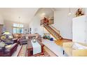 Two-story living room with hardwood floors, staircase, and high ceilings at 6990 Orchard Ct, Arvada, CO 80007