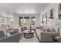 Bright living room featuring hardwood floors, recessed lights, neutral decor, and large windows at 14769 Dahlia St, Thornton, CO 80602