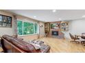 Bright living room featuring a brick fireplace and hardwood floors at 7722 W 1St Pl, Lakewood, CO 80226