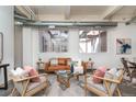 Bright living room with exposed ductwork, large windows, contemporary furnishings, and stylish decor at 1777 E 39Th Ave # 209, Denver, CO 80205