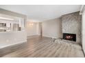 Spacious living room with stone fireplace and wood-look floors at 10001 E Evans Ave # D, Aurora, CO 80247