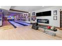 Basement bowling alley with modern fireplace, basketball art, and two lanes at 5650 E Stanford Dr, Cherry Hills Village, CO 80111