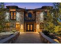 Stunning stone home with a beautiful walkway leading to an ornate double door entrance at 5650 E Stanford Dr, Cherry Hills Village, CO 80111