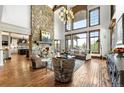 Bright living room featuring a stone fireplace, wood floors, and expansive windows at 5650 E Stanford Dr, Cherry Hills Village, CO 80111