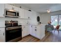 Modern kitchen with white cabinets, stainless steel appliances, and wood-look flooring at 10359 W Fair Ave # F, Littleton, CO 80127