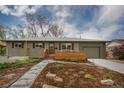 Inviting single-story home with well-manicured front yard, landscaping, and wooden accent wall at 4655 Ludlow St, Boulder, CO 80305