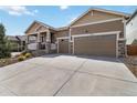 Inviting home featuring a two-car garage, attractive yard, and comfortable front porch at 2724 Rising Moon Way, Castle Rock, CO 80109