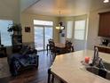 Dining room with dark wood floors and modern lighting at 10636 Racine Cir, Commerce City, CO 80022