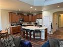 Open kitchen with a breakfast bar and dark wood cabinets at 10636 Racine Cir, Commerce City, CO 80022