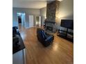 Open concept living room with wood flooring and a floor-to-ceiling stone fireplace at 7020 W Portland Ave, Littleton, CO 80128