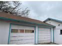Spacious two-car garage featuring white doors with blue trim, offering ample parking and storage space at 5515 Zuni St, Denver, CO 80221