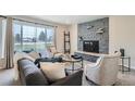 Inviting living room with stone fireplace, sofa, chairs and large picture window at 14505 W 52Nd Ave, Arvada, CO 80002