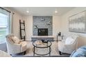 Cozy living room with a gray stone fireplace, plush seating, and natural light at 14505 W 52Nd Ave, Arvada, CO 80002