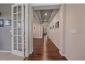Bright hallway with hardwood floors, decorative lighting, and neutral paint at 15201 Yellowthroat St, Parker, CO 80134