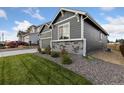 Side view of the house, showcasing gray siding and stone accents at 3037 Lake Helen Blvd, Mead, CO 80542