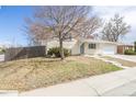 View of the well-maintained brick home, landscaped front yard, concrete steps, and a partial view of the driveway at 5542 Sable St, Denver, CO 80239