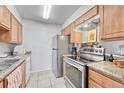Bright kitchen with stainless steel appliances, tile flooring, and light wood cabinets at 14226 E 1St Dr # B10, Aurora, CO 80011