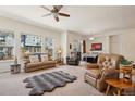 Bright living room featuring plush seating, a ceiling fan, and a view into the dining area at 4553 Red Deer Trl, Broomfield, CO 80020