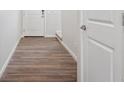 Hallway with hardwood-style flooring and a white door leading to other areas of the home at 19059 E 94Th Pl, Commerce City, CO 80022