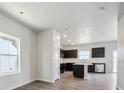 Open-concept kitchen with dark cabinets, stainless steel appliances, and a center island at 19059 E 94Th Pl, Commerce City, CO 80022
