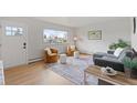 Bright living room with hardwood floors, comfortable seating, and a large window offering pleasant views at 865 S Everett St, Lakewood, CO 80226