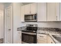 Kitchen features white cabinets, stainless steel appliances, and granite countertops at 7433 S Quail Cir # 1924, Littleton, CO 80127