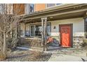 Inviting front porch with string lights, seating, and a vibrant red door with seasonal wreath at 21613 E 59Th Pl, Aurora, CO 80019