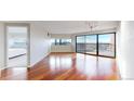 Bright living room with wood floors, large windows, and a view into the bedroom at 100 Park W Ave # 1806, Denver, CO 80205