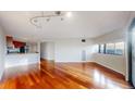 Bright living room with hardwood floors, track lighting, and a view of the kitchen at 100 Park W Ave # 1806, Denver, CO 80205