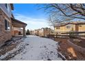 Landscaped backyard with a snow-covered ground and wooden fence at 23541 E Portland Way, Aurora, CO 80016