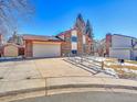 Front view of the house showcasing the yard and driveway at 2066 S Rifle St, Aurora, CO 80013