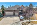 Beautiful brick home showcasing a three-car garage and landscaped front yard at 26426 E Peakview Dr, Aurora, CO 80016