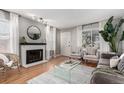 Bright living room with white fireplace, hardwood flooring, and natural light at 1745 S Kline Way, Lakewood, CO 80232