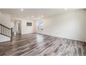 Bright living room with sleek flooring, recessed lighting, and staircase at 26267 E 3Rd Ave, Aurora, CO 80018
