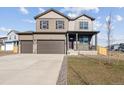 Two-story home featuring a covered porch, three car garage, and front lawn at 4107 Marble Dr, Mead, CO 80504