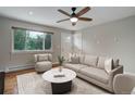 Bright living room with hardwood floors, neutral walls, ceiling fan and large windows at 9743 W 67Th Pl, Arvada, CO 80004