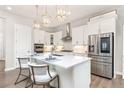 Modern kitchen with white cabinets, quartz countertops, stainless steel appliances, and pendant lighting at 21972 E Allenspark Dr, Aurora, CO 80016