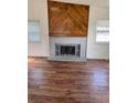 Spacious living room featuring hardwood floors and a rustic fireplace at 14425 E Albrook Dr, Denver, CO 80239