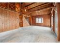 Expansive living area with wooden walls, ceiling beams and a rustic staircase at 8409 S Otis St, Littleton, CO 80128