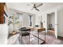 Bright home office with large window, modern desk, and view of hall to entryway at 425 S Reed St, Lakewood, CO 80226