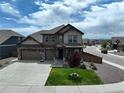 Exterior shot featuring a two-story home with a three car garage, stone accents, and manicured lawn at 1624 Pinion Wing Cir, Castle Rock, CO 80108