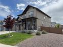 View of a two-story home with craftsman architecture, stone accents and a well-maintained lawn at 1624 Pinion Wing Cir, Castle Rock, CO 80108