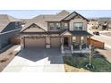 Stunning two-story home featuring a covered porch, a three-car garage and beautiful stone and siding accents at 1624 Pinion Wing Cir, Castle Rock, CO 80108