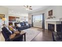 Cozy living room with a fireplace, large window, and stylish decor with an open view to the kitchen at 26642 E Peakview Pl, Aurora, CO 80016