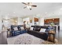 Cozy living room with open floor plan, dark wood floors, area rug, and leather sofas at 26642 E Peakview Pl, Aurora, CO 80016