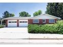 Red brick home with a three car garage and a paved driveway at 2900 S Golden Way, Denver, CO 80227