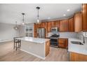 Modern kitchen boasts stainless steel appliances, a center island, and warm wood cabinets at 11788 Mill Valley St, Parker, CO 80138
